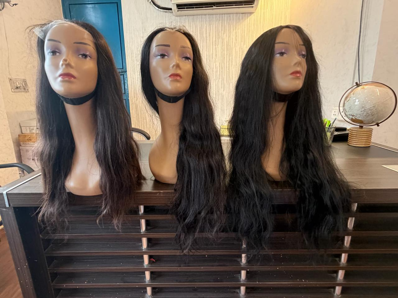 Suraj Hair Industries showroom — premium human hair wigs on mannequins
